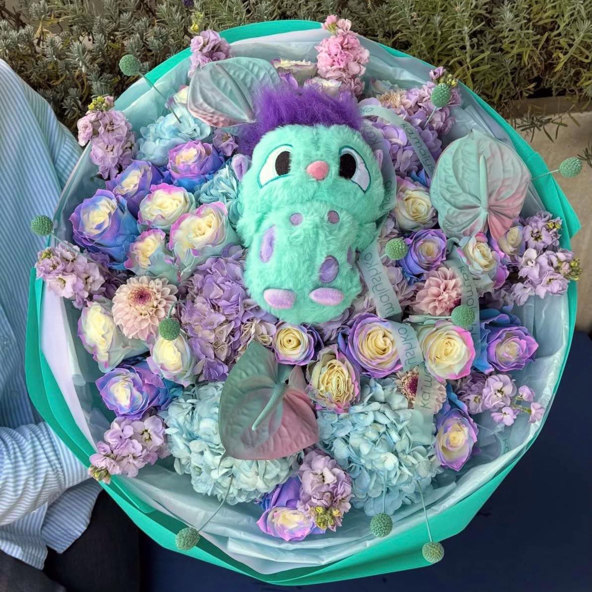 دسته گل آبی بنفش با رز و لیلیوم و کاغذ آبی فیروزه ای و عروسک bibble