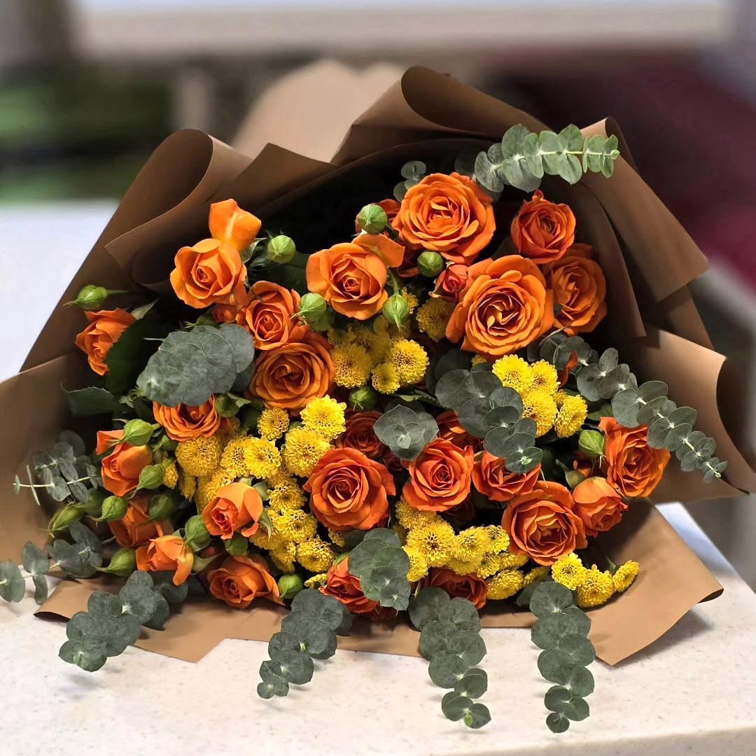 دسته گل پاییزی با رز نارنجی داوودی زرد و کاغذ نسکافه ای